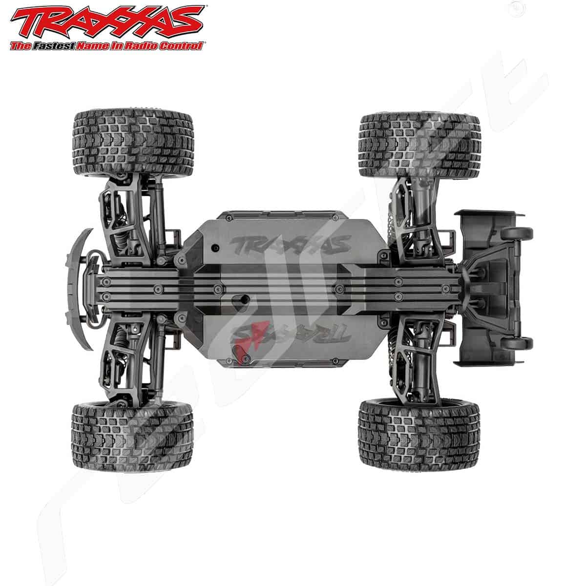 Traxxas radio vadāms modeļa auto, pilnībā redzams no apakšas, ar lielām riepu un precīzu konstrukciju.